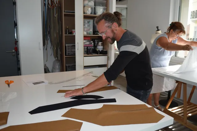 Stagiaire homme en train de préparer les pièces pour un gilet lors d&apos;une formation professionnelle de couture chez FLK Creations.